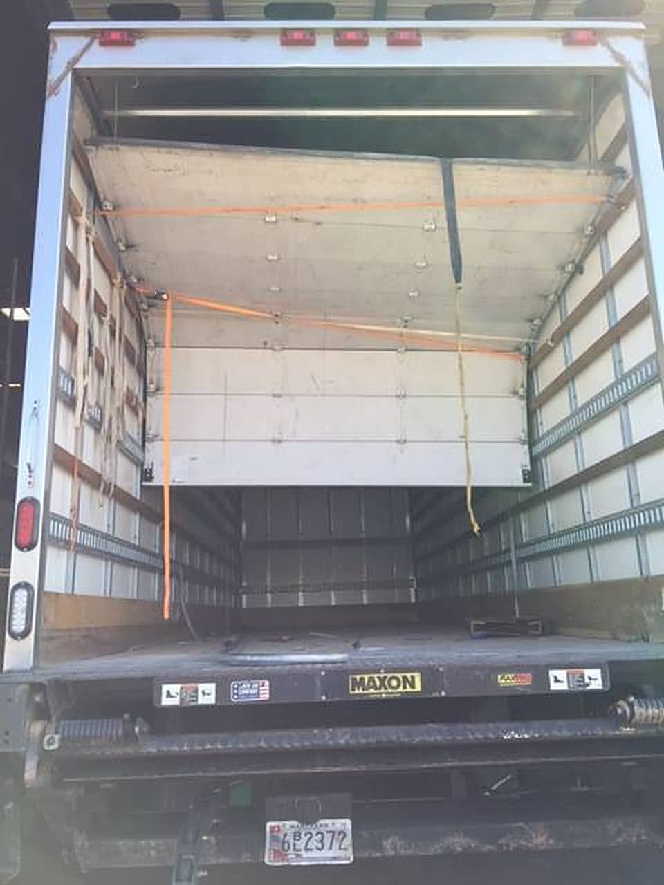 The rear of a box truck with its roll-up door open