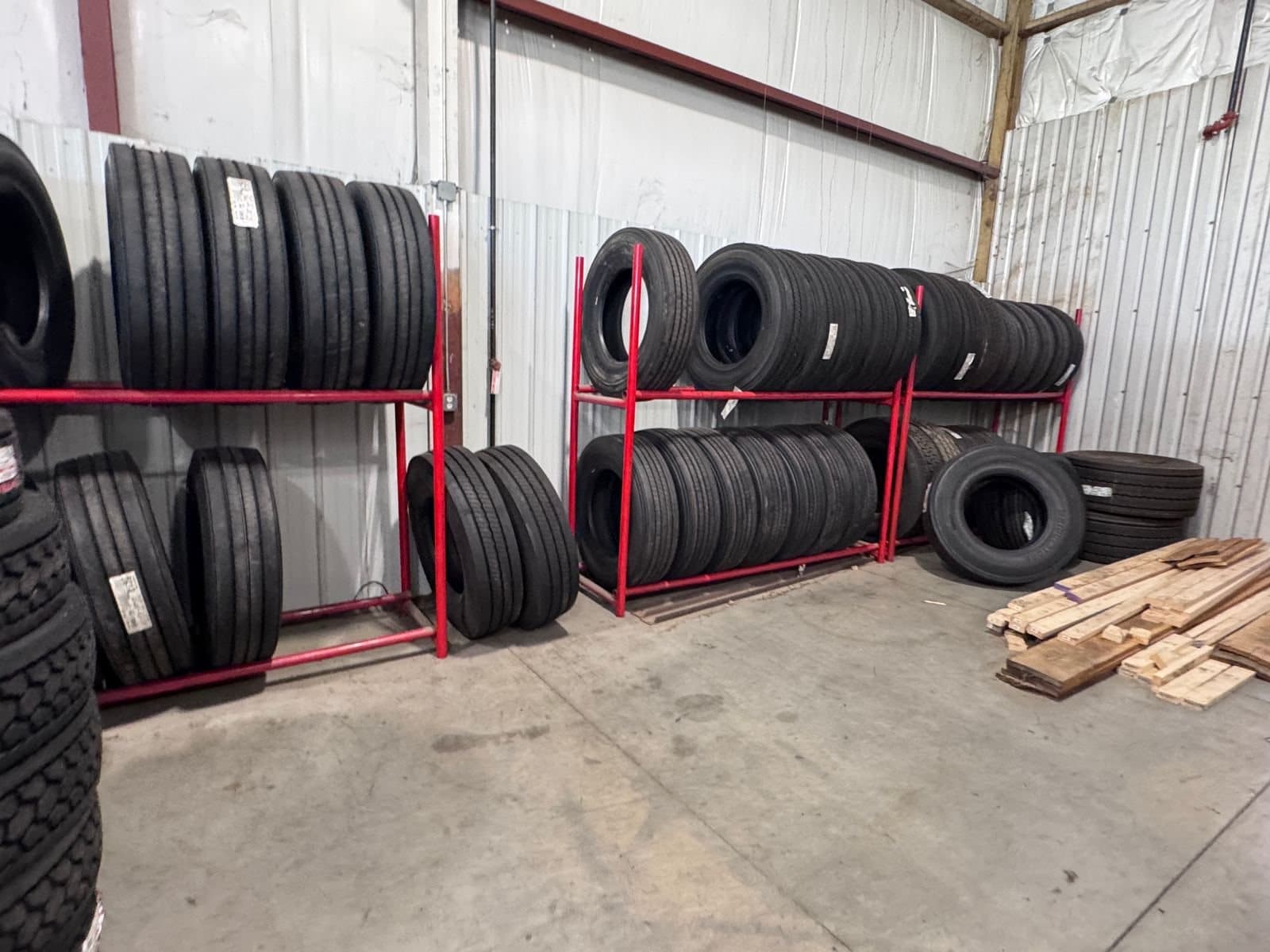 Commercial truck tires on red racks along the shop wall