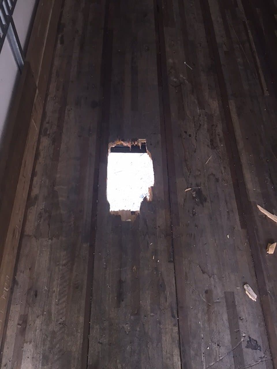 A hole worn through the wood floor of a trailer, waiting on repair