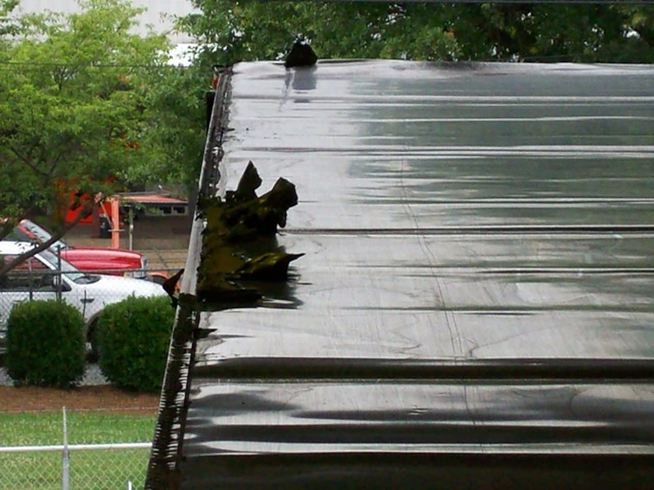 A torn trailer roof waiting on repair at the shop